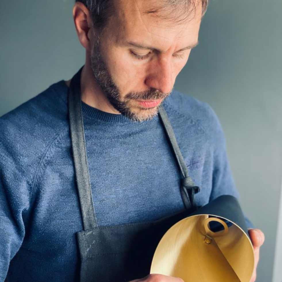 British craftsman inspecting the quality of the shades on this luxury chandelier made by Arcform and supplied by South Charlotte Fine Lighting