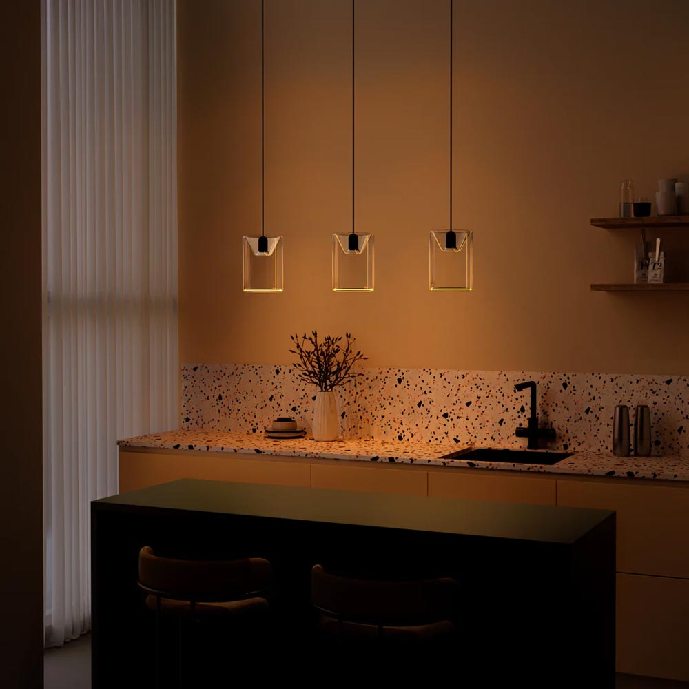 Azure Cylinder Linear 3 Drop Chandelier lit up over a kitchen bar