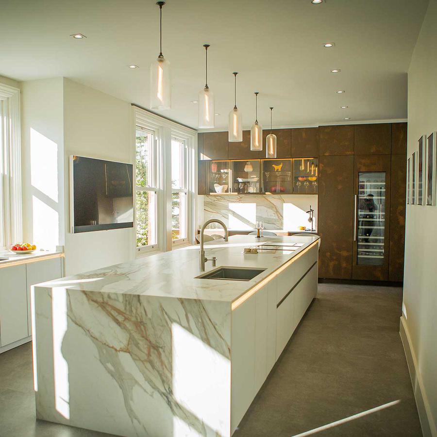 Richmond pendant lighting sold by South Charlotte Fine Lighting. Picture shows a row of Richmond pendant lights above a kitchen island.