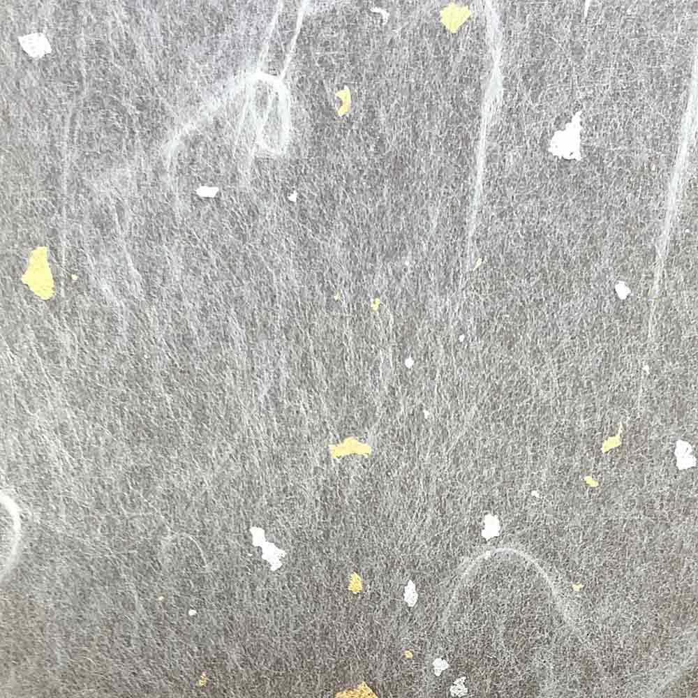 Gold and silver flecks shown here in a close-up on the material used in the Musrhroom Washi pendant light sold by South Charlotte Fine Lighting