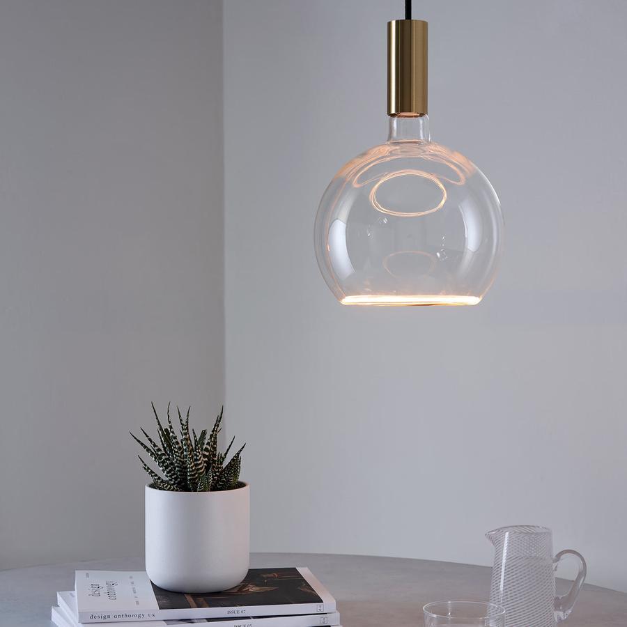 Well Lit Spin Pendant Light in Brass, pictured here with the Well Lit Azure Globe G200 LED Light bulb, offers pendant lighting for your dining table