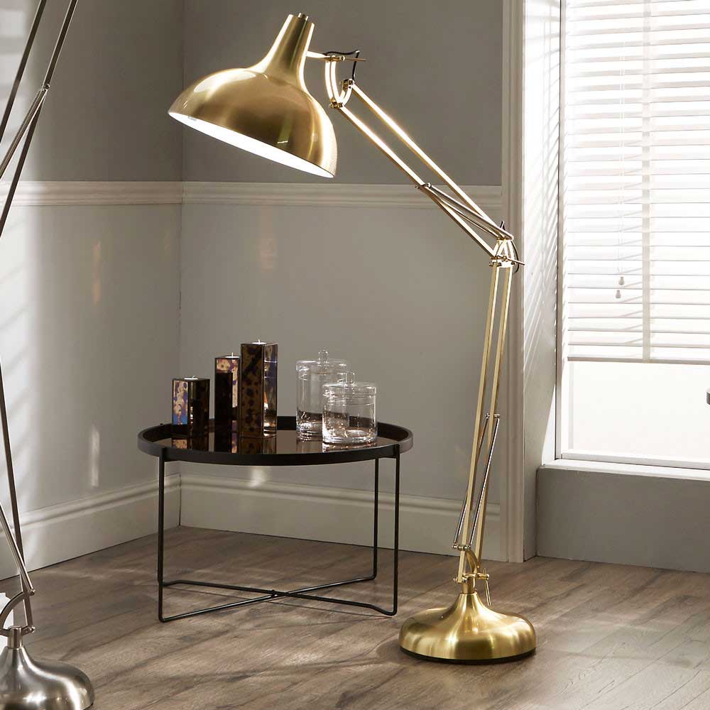 The Alonzo in brass effect is pictured in a living room where it will be ideal as a floor lamp for reading