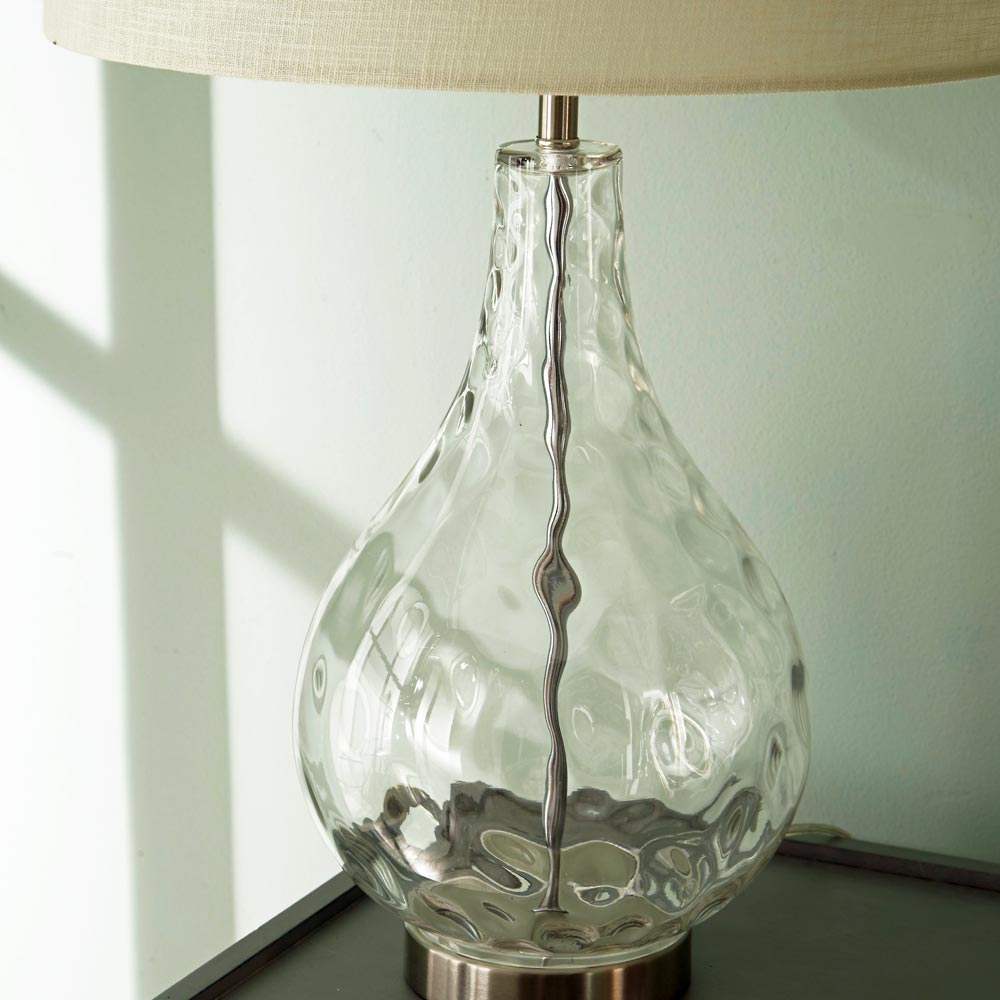 Charlotte table lamp with shade features a clear base with dimpled glass