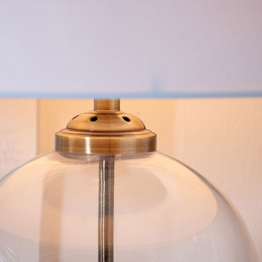Cloche modern table lamp features an antique brass-style metalwork throughout