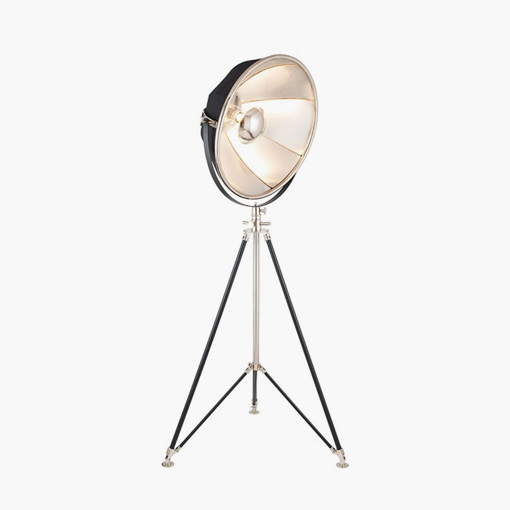 Elstree Black and Silver MEtal Tripod Floor Lamp in black and silver from South Charlotte Fine Lighting is shown with its light on.