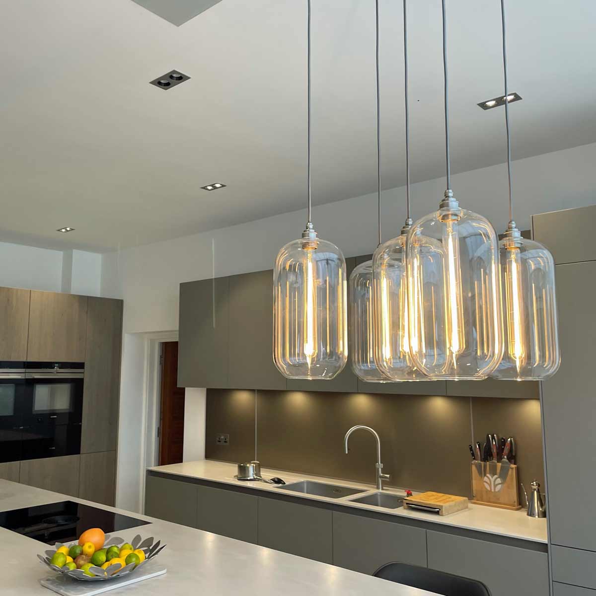 Pendant lights sold by South Charlotte Fine Lighting pictured above a kitchen worktop