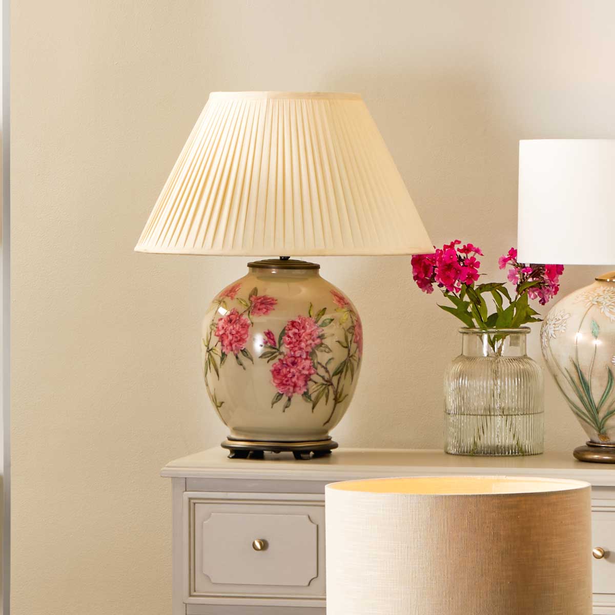 Beautiful lifestyle image of Jenny Worrall vintage floral table lamp with rhododendrons and a distressed gold and off-white background