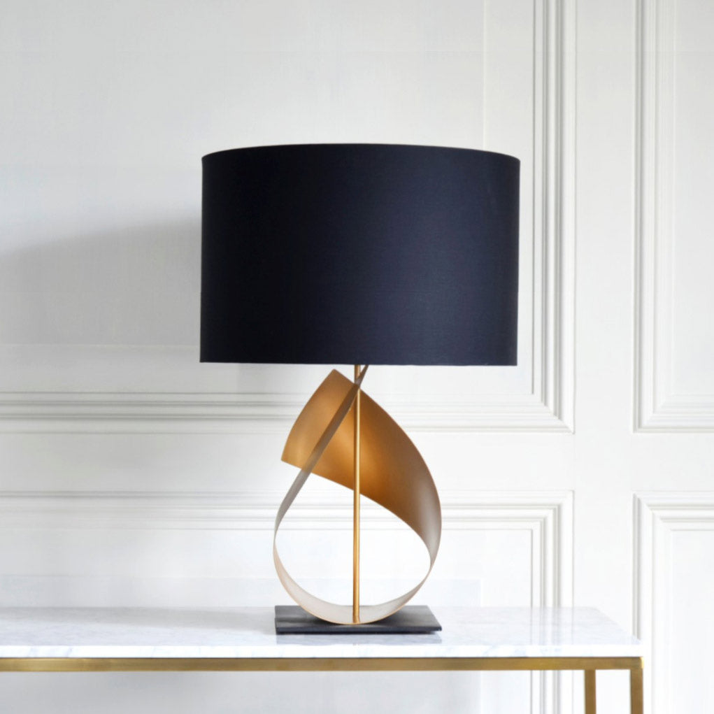 Handmade FLUX table lamp’s sweeping gold curves make it perfect for your living room.